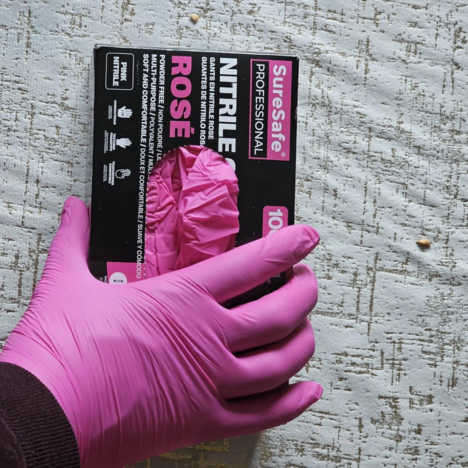 Professional sugarist wearing SureSafe Rose pink nitrile gloves showing a snug, soft, and comfortable fit.